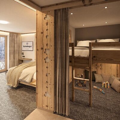 Schlafzimmer im Bauernhof mit Doppelbett, Etagenbett und einem Fenster mit Blick auf die verschneite Landschaft.