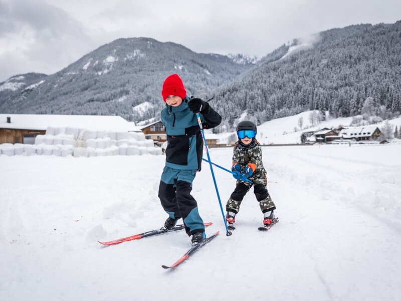 Winterlicher Spaß direkt am Bauernhof mit viel Platz zum Skifahren im Schnee vor einer malerischen Bergkulisse.