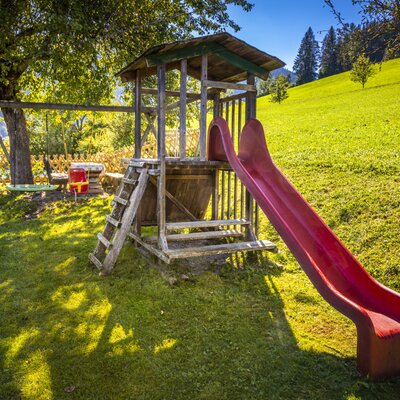 Kinderspielplatz mit Rutsche und Schaukeln auf dem Hof.