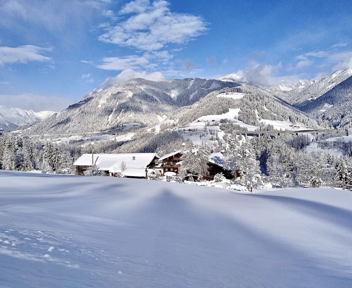 Winterlandschaft mit schneebedeckten Bergen und Bäumen.