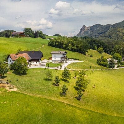 Der einladende Bauernhof inmitten von saftig grünen Wiesen und einer malerischen Bergkulisse.