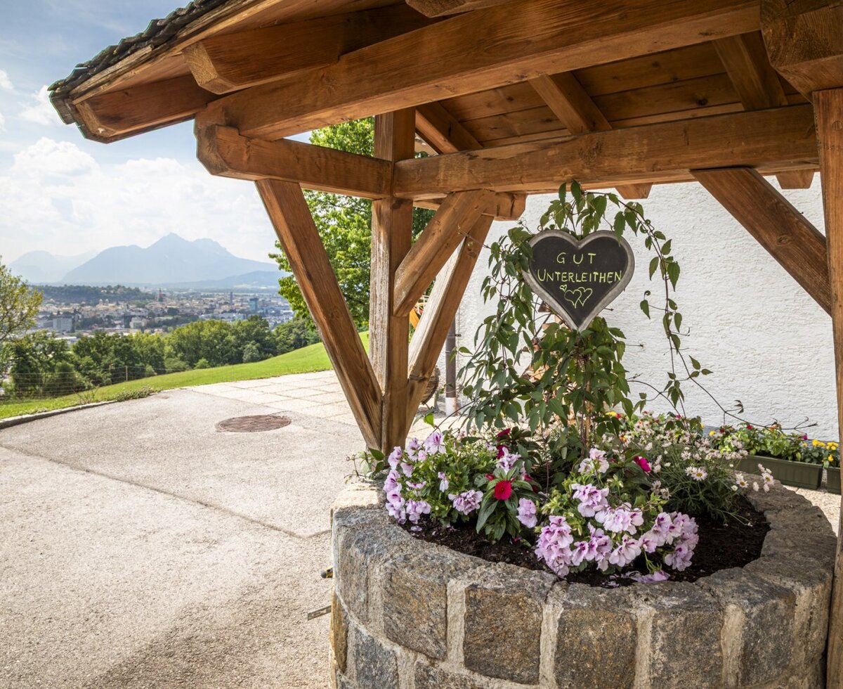 Ein liebevoll gestalteter Blumenbrunnen auf dem Bauernhof mit herrlichem Ausblick auf die umliegende Landschaft.