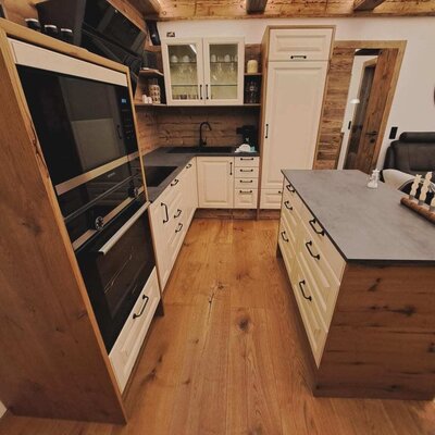 Moderne Küche der Ferienwohnung mit Backofen, Mikrowelle, Spüle und Kücheninsel.