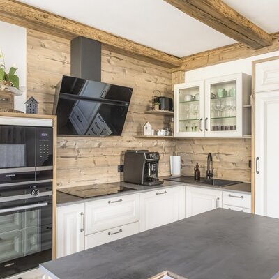 Voll ausgestattete Küche in der Ferienwohnung mit Backofen, Mikrowelle, Induktionskochfeld, Kaffeemaschine und Kücheninsel.
