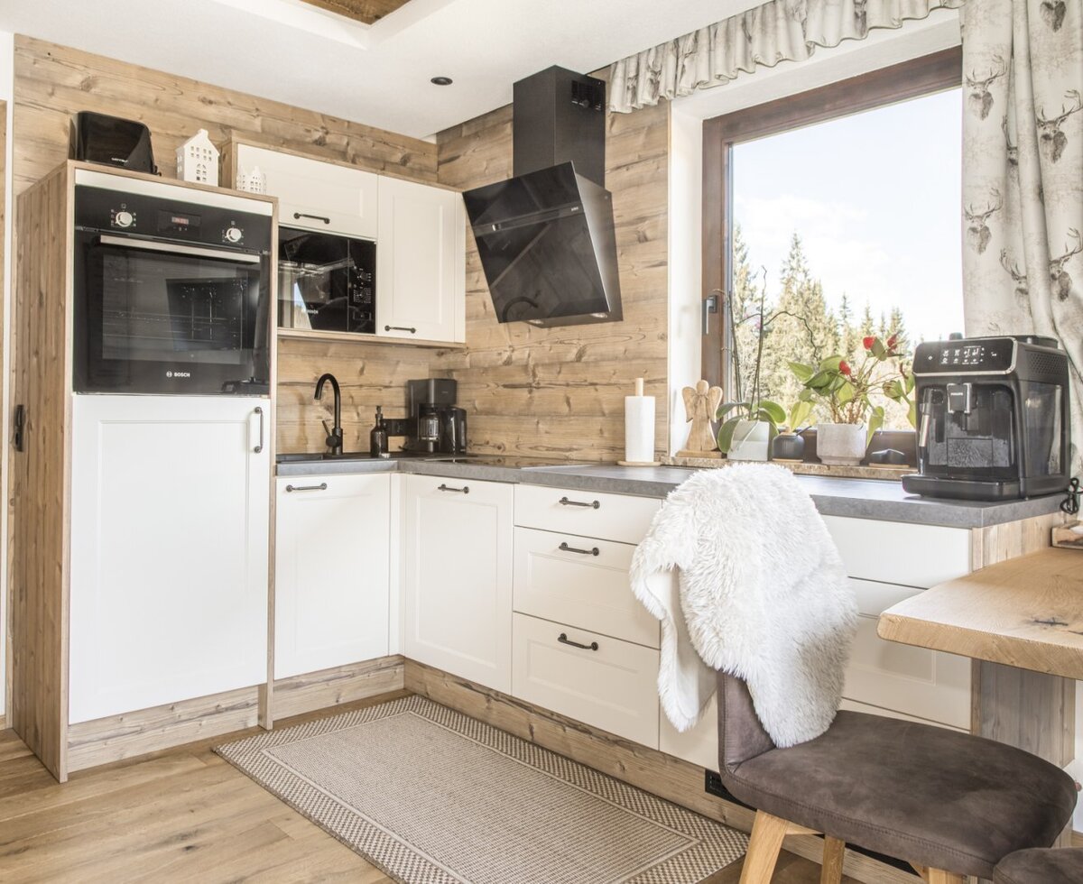 Moderne Küche in der Ferienwohnung mit Backofen, Mikrowelle, Kaffeemaschine und Essbereich.