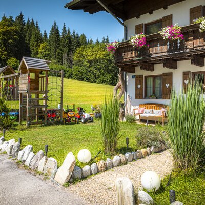 Die einladende Ferienwohnung mit einem gepflegten Garten, gemütlichen Sitzgelegenheiten und einem abenteuerlichen Kinderspielplatz.