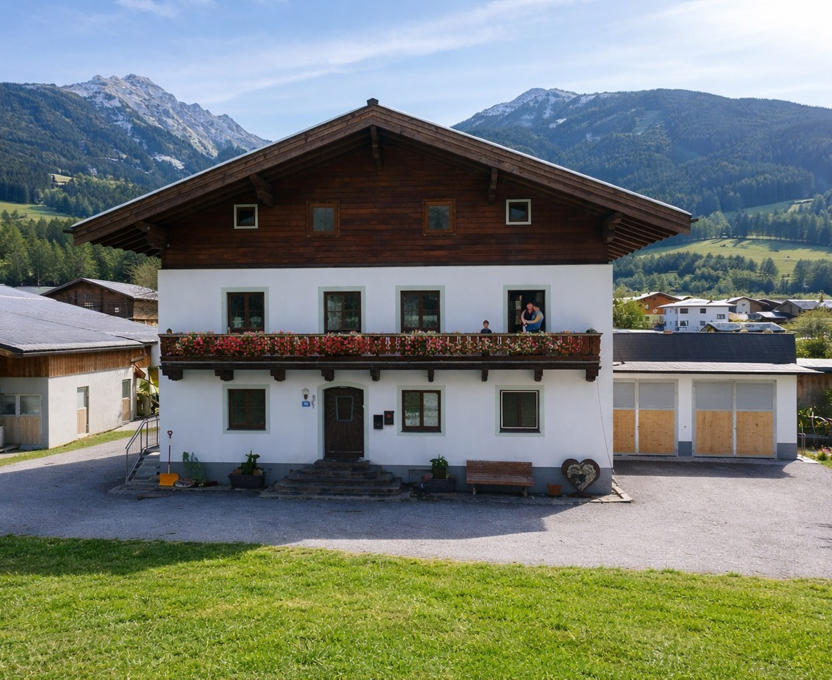 Außenansicht vom Bauernhof mit Balkon und Bergblick.