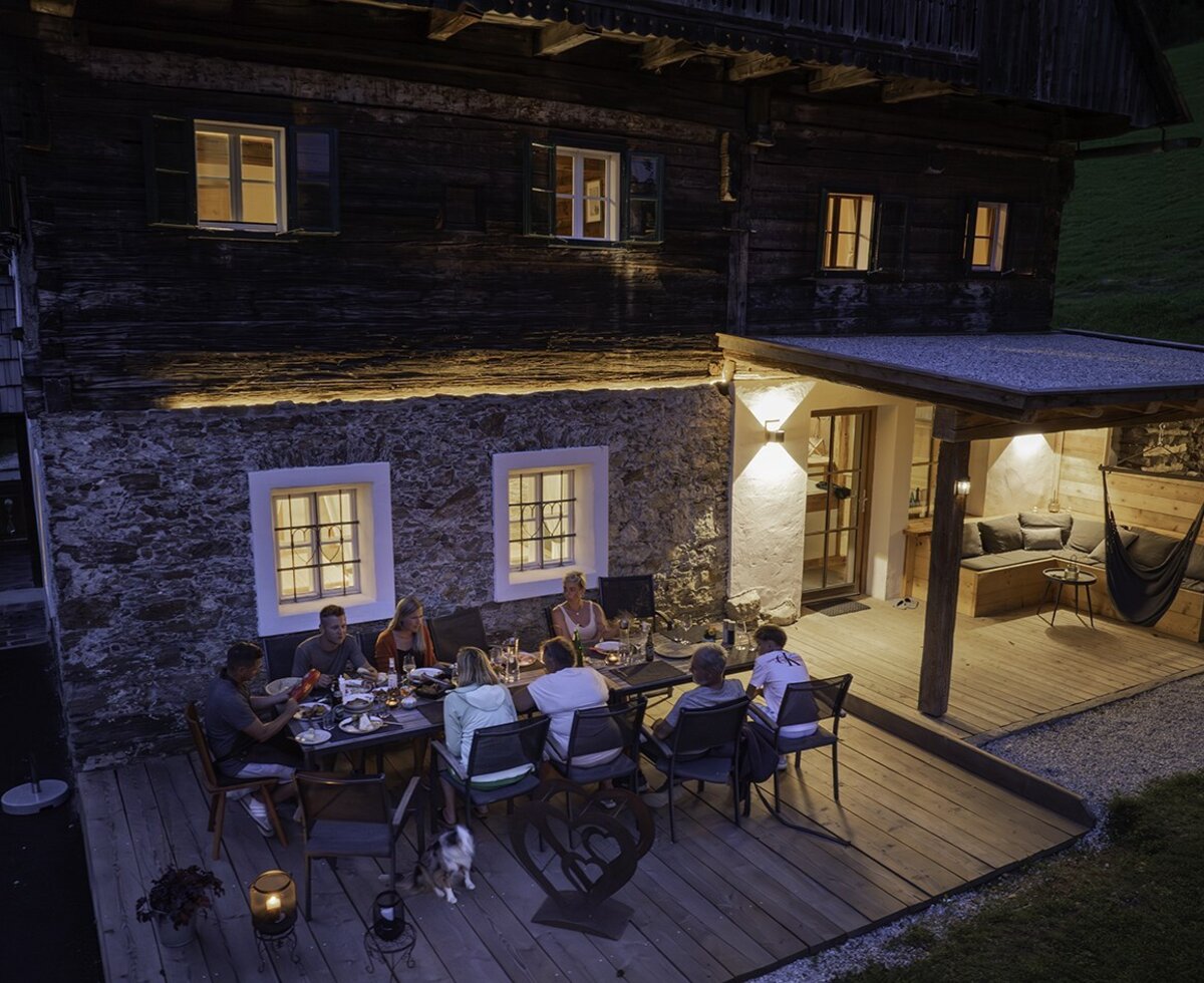 Die Terrasse des Bauernhofs bietet einen Esstisch für Mahlzeiten im Freien und einen überdachten Loungebereich mit Sitzgelegenheiten und Hängematte.