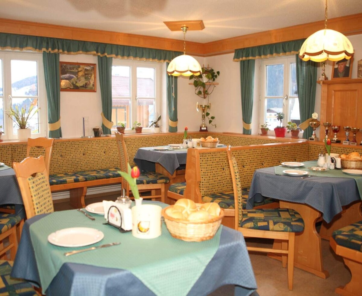 Der gemütliche Frühstücksraum des Bauernhofs mit einladenden Sitzecken im traditionellen Holzstil und warmer Beleuchtung.