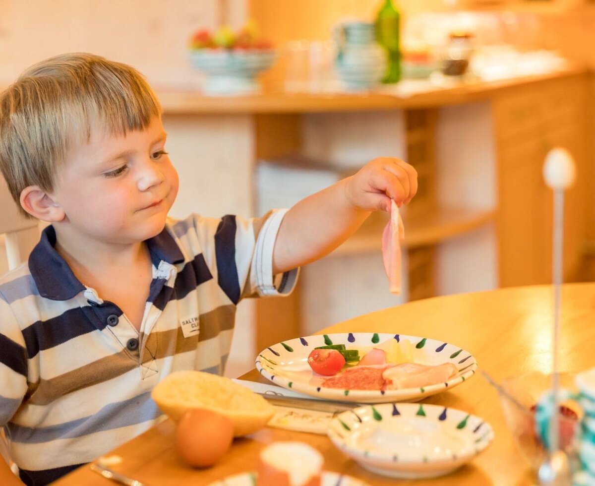 Ein herzhaftes Frühstück für die kleinen Gäste im gemütlichen Essbereich des Bauernhofs.