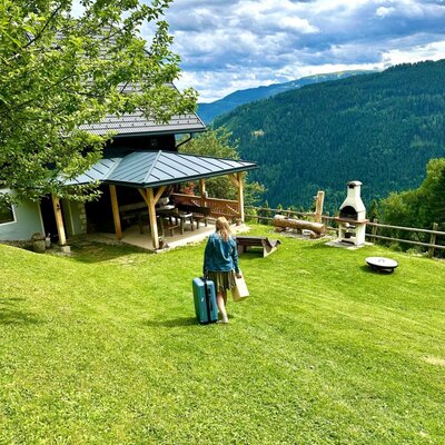 Der Hof bietet eine überdachte Terrasse, einen Grillplatz und eine große Rasenfläche mit Bergblick.