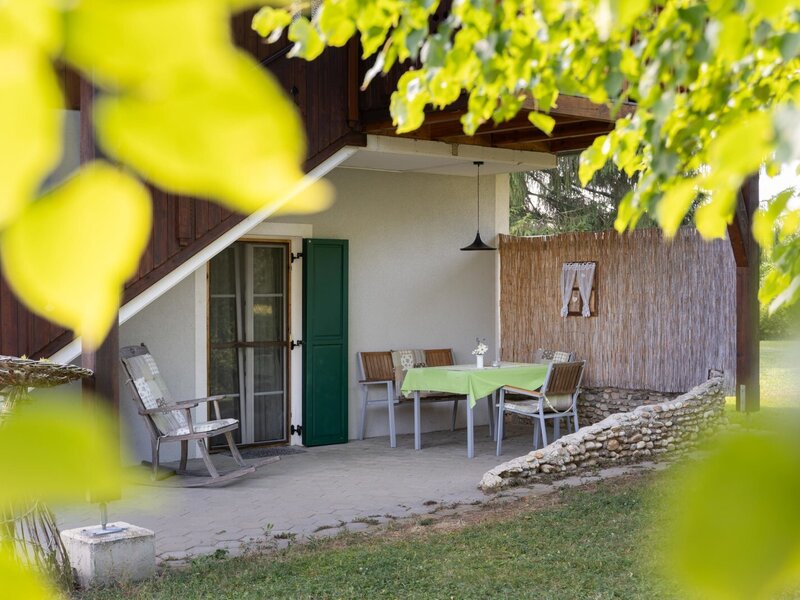 Die Sitzterrasse am Bauernhof ist mit einem Tisch und Stühlen ausgestattet und bietet direkten Zugang zum Bauerngarten.