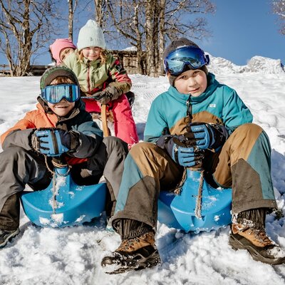 Kinder beim Rodeln im Schnee auf der Rodelwiese hinter dem Hof. (c)Wolfgang Spekner