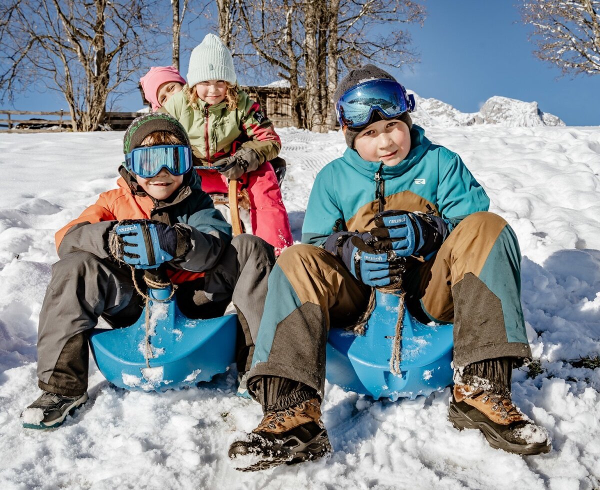 Kinder beim Rodeln im Schnee auf der Rodelwiese hinter dem Hof. (c)Wolfgang Spekner