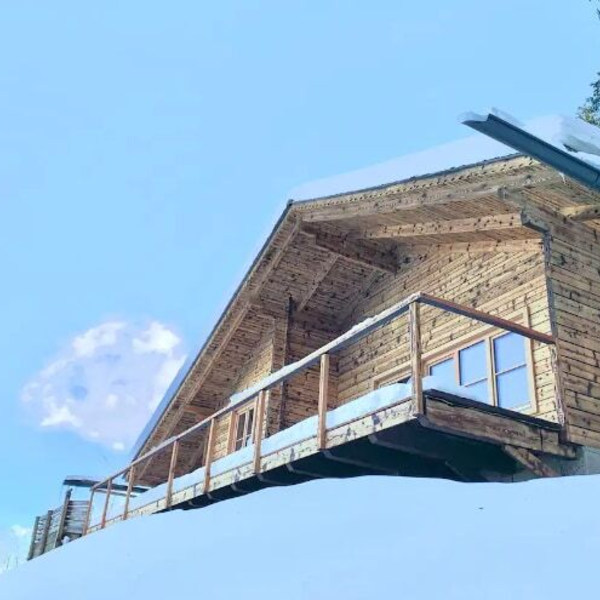 Der Hof in Holzbauweise mit Balkon und schneebedecktem Dach.