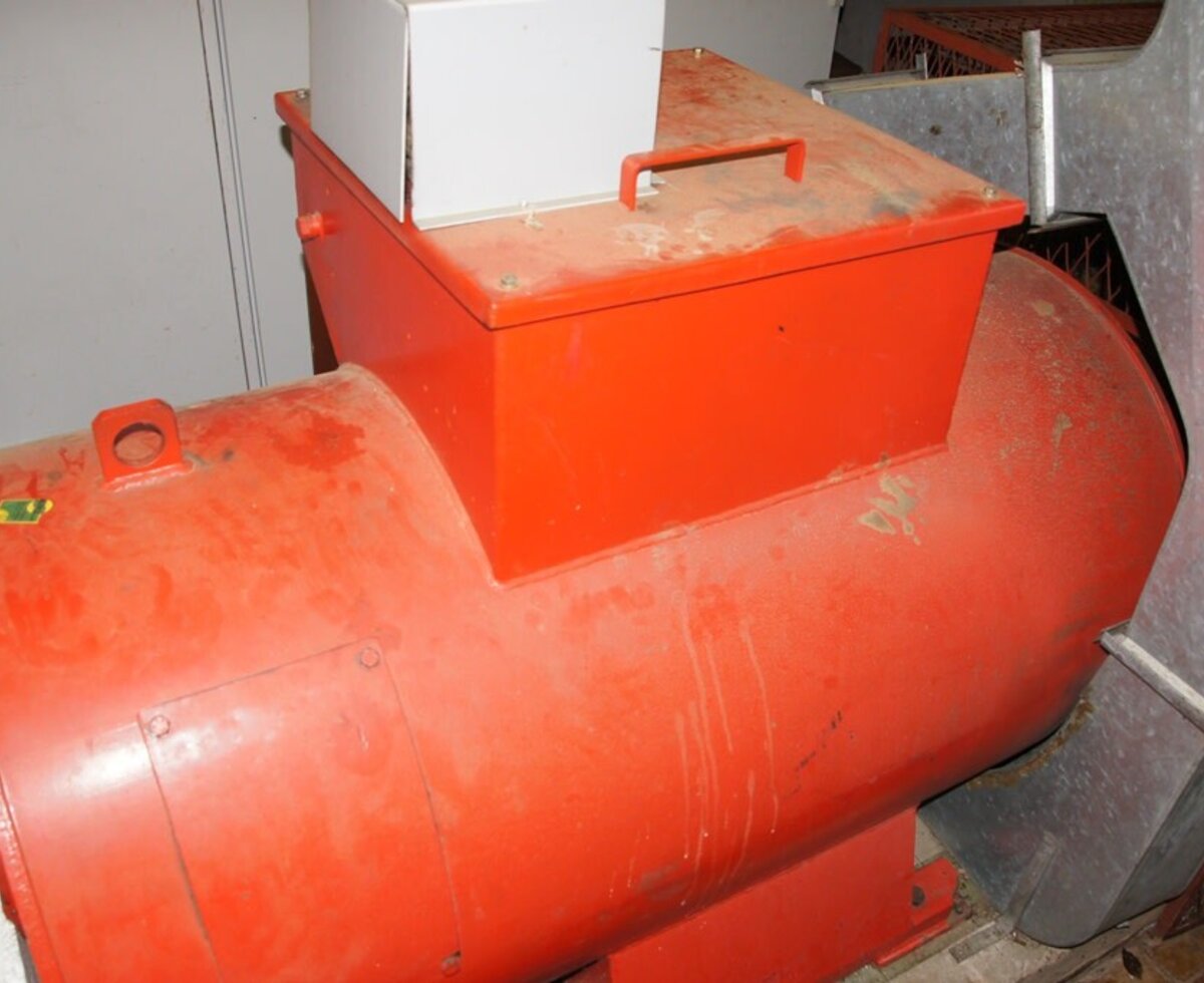 Technische Anlage des Bauernhofs mit einer großen roten Maschine und Metallkanälen.