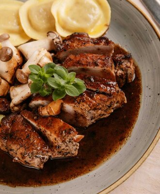 Kalbrückensteak vom Bio-Bauernhof, Pilzen und Ravioli in dunkler Soße, angeboten auf dem Bauernhof.
