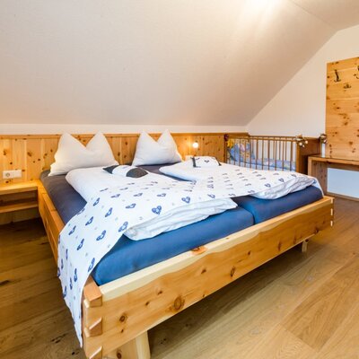 blaues Zirbenschlafzimmer mit Gitterbett