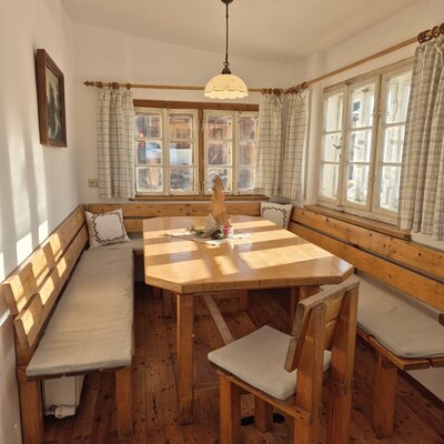 Essbereich in der Wohnstube des Hofs mit Holztisch und Eckbank.