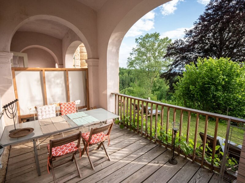 Eine einladende, überdachte Terrasse unter den Arkaden mit einem gemütlichen Sitzbereich und Blick ins Grüne. (c) Stephan Friesinger