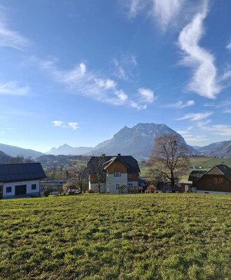 Der Bauernhof, umgeben von grünen Wiesen, bietet einen Blick auf die umliegende Naturlandschaft und die Berge.