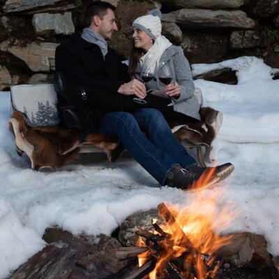 Der Sitzbereich mit offener Feuerstelle des Blockhauses, umgeben von Schnee.