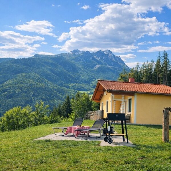 Außenbereich des Bed and Breakfast mit Terrasse, Grill, Liegestühlen und Bergblick.