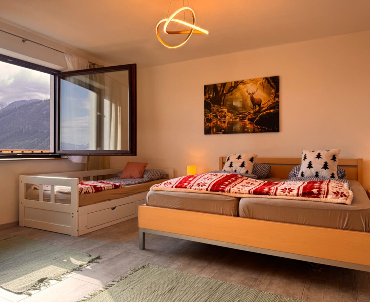 Schlafzimmer im Bed and Breakfast mit Doppelbett, zusätzlichem Einzelbett und Bergblick aus dem Fenster.
