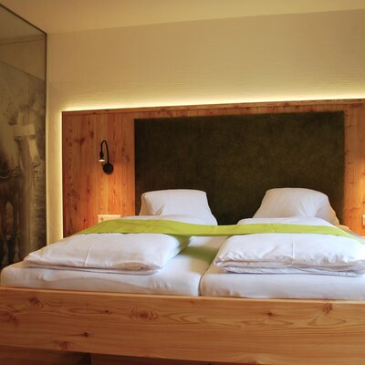 Geräumiges Schlafzimmer im Bauernhof mit Doppelbett, Holzvertäfelung und alpiner Einrichtung.