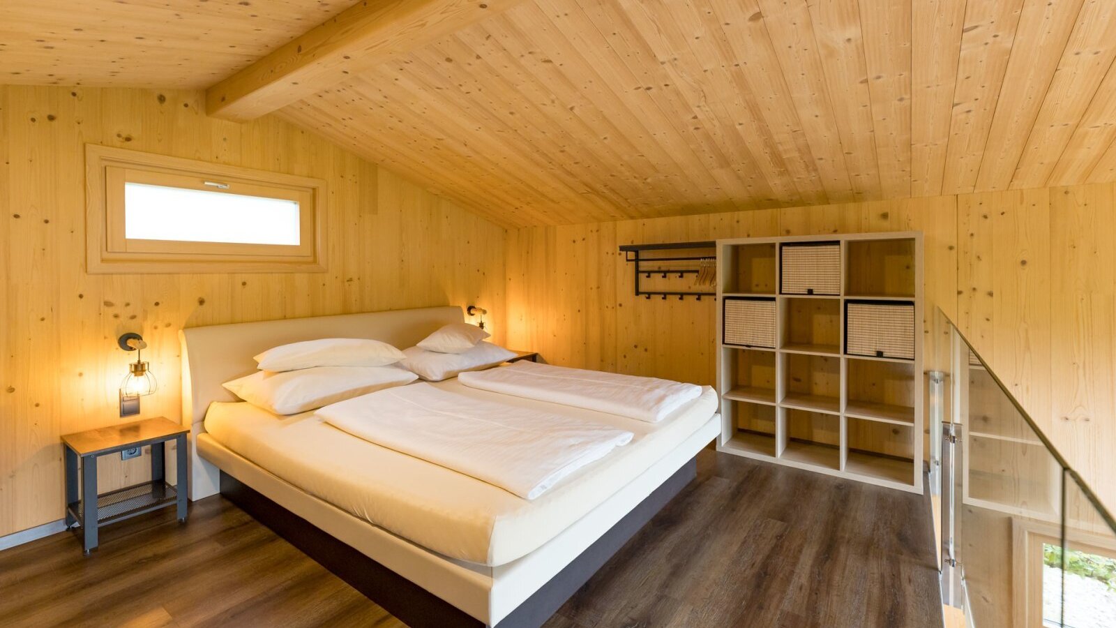 Schlafzimmer im Chalet mit Boxspringbett oder Wasserbett Holzvertäfelung und Ablageregal. copyright: ELISABETH FRÖHLICH photography