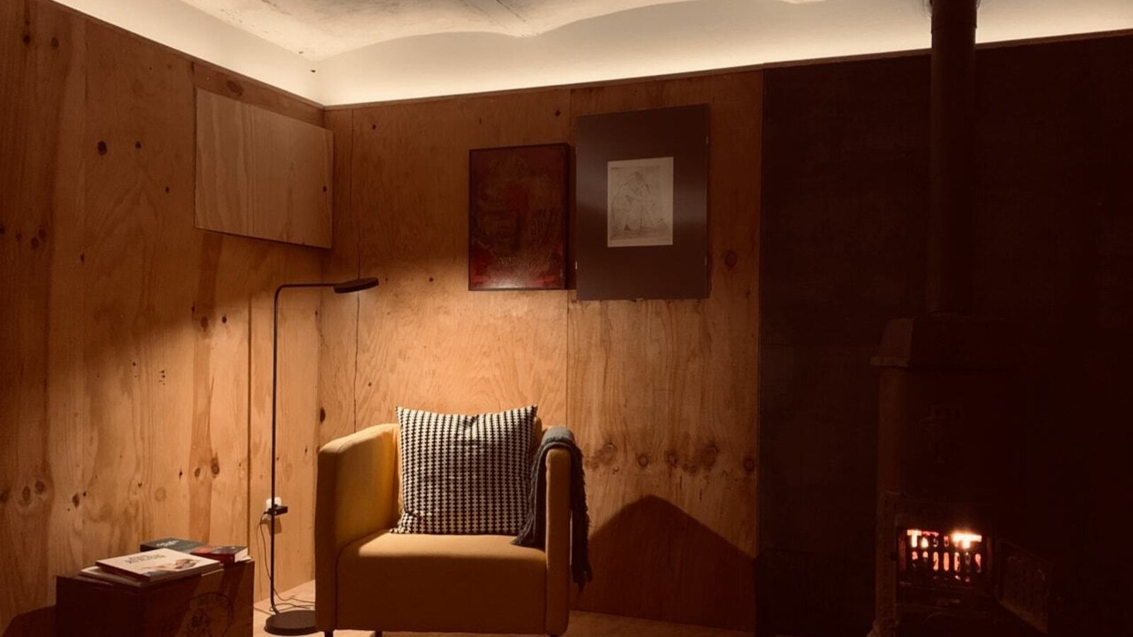 Der Bauernhof verfügt über einen Sitzbereich mit Kaminofen, Sessel und indirekter Beleuchtung.