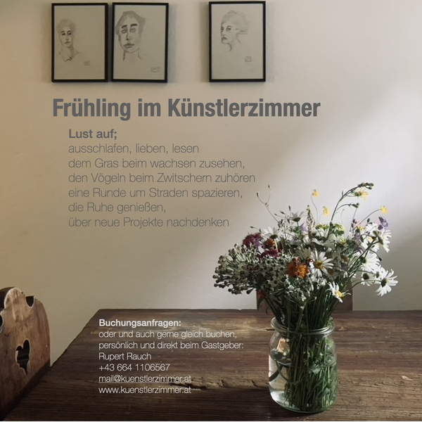 Holztisch mit einem Strauß Wildblumen und gerahmten Zeichnungen an der Wand im Bauernhof.