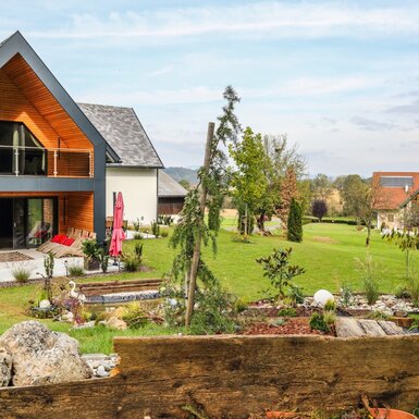 Der moderne Anbau des Bauernhofs verfügt über einen Balkon, eine Terrasse und einen gestalteten Garten mit Teichanlage.
