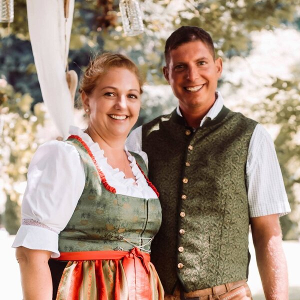 Die Gastgeber des Bauernhofs in traditioneller Kleidung.