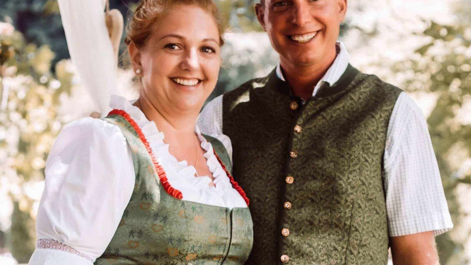 Die Gastgeber des Bauernhofs in traditioneller Kleidung.