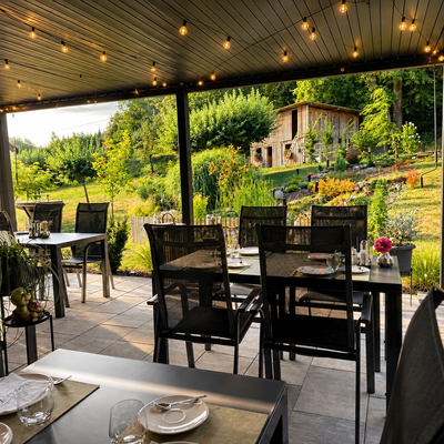 Die einladende, überdachte Terrasse des Bauernhofs mit gemütlichen Sitzgruppen und Blick auf den idyllischen Garten.