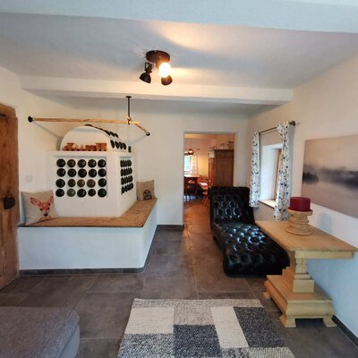 Der restaurierte Kachelofen bringt Wärme in das Wohnzimmer, das Badezimmer und das Vorhaus