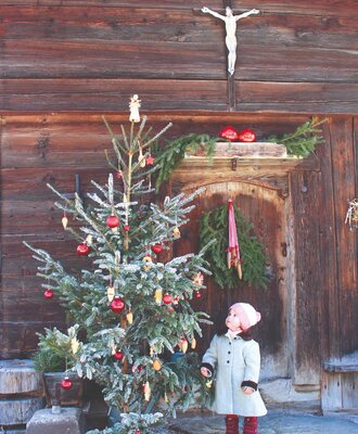 Weihnachtliche Dekoration mit einem Tannenbaum am Eingang des Bauernhofs.