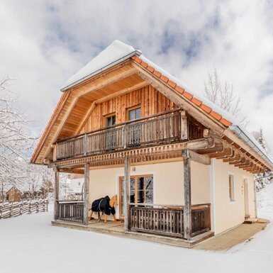 Das Ferienhaus auf dem Bauernhof mit Holzbalkon und überdachter Terrasse im Winter.