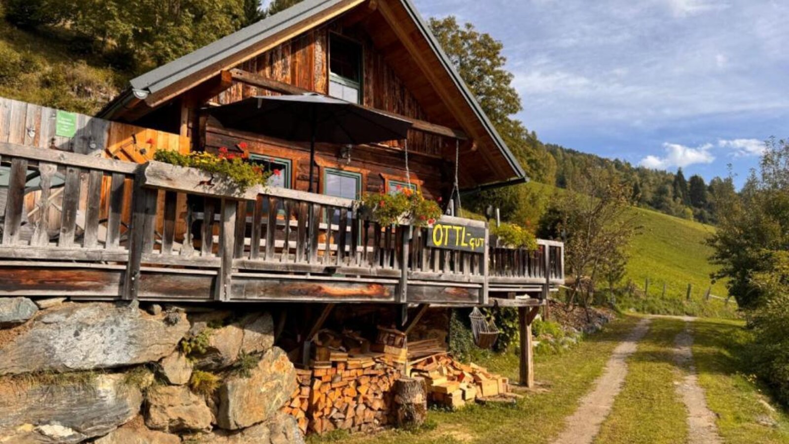 Die Ottls Hütte aus Holz mit einer einladenden Terrasse inmitten idyllischer Natur.