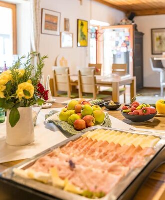 Das hervorragende Frühstücksbuffet mit Aufschnitt, Käse, frischem Obst und Gemüse, angerichtet in einem hellen Speiseraum.