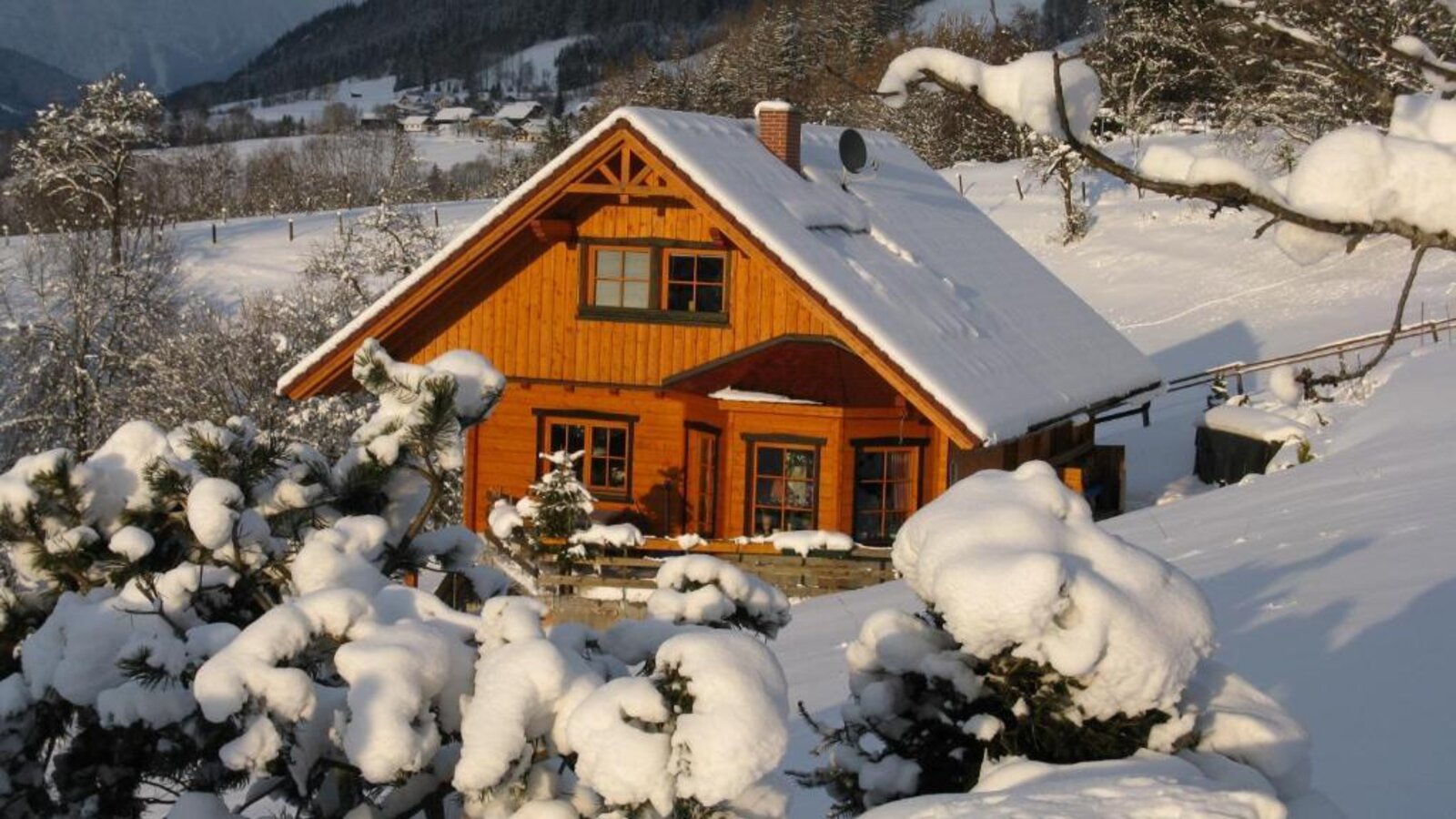 Das Ferienhaus im Winter, umgeben von Schnee und Bergen.