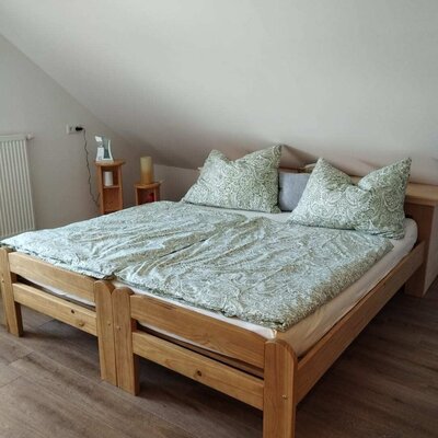Schlafzimmer im Bed and Breakfast mit einem Doppelbett aus Holz, zwei Nachttischen und Dachschräge.