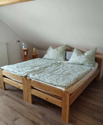 Schlafzimmer im Bed and Breakfast mit einem Doppelbett aus Holz, zwei Nachttischen und Dachschräge.