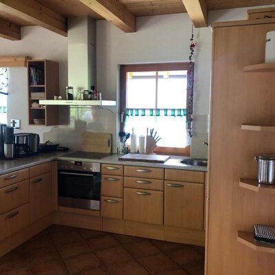 Die Küche des Bed and Breakfast mit Herd, Spüle, Kaffeemaschine und Holzbalkendecke.