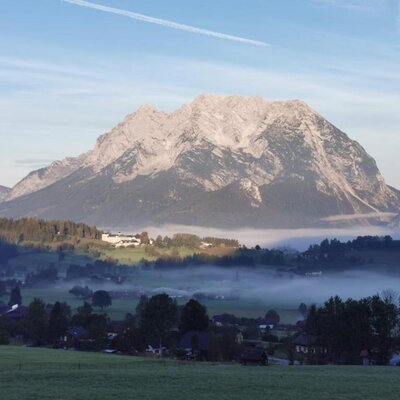 Die Aussicht vom Bed and Breakfast auf die Berge, ein nebliges Tal und ein Dorf.