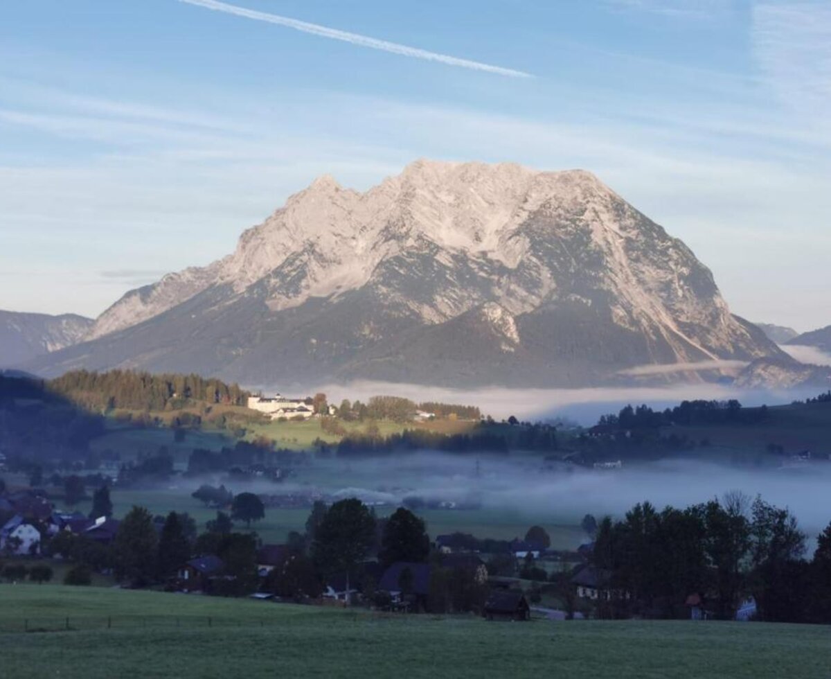 Die Aussicht vom Bed and Breakfast auf die Berge, ein nebliges Tal und ein Dorf.