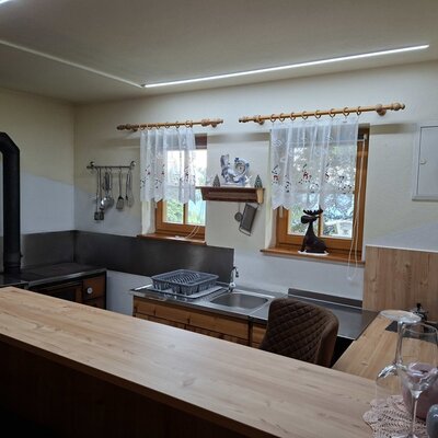 Die Küche des Bed and Breakfast mit Holzarbeitsplatte, Spüle, traditionellem Herd und Kaffeemaschine.