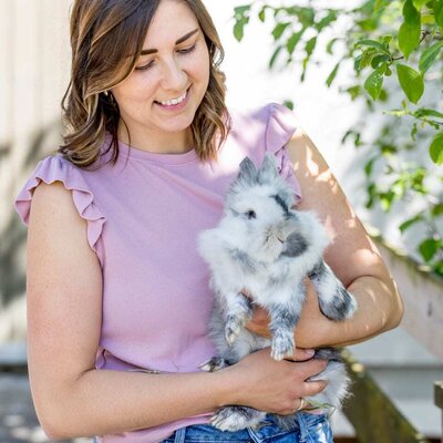 Karin, die Chefin, hält Kaninchen Schneeflocke, eines der Tiere auf dem Bauernhof.