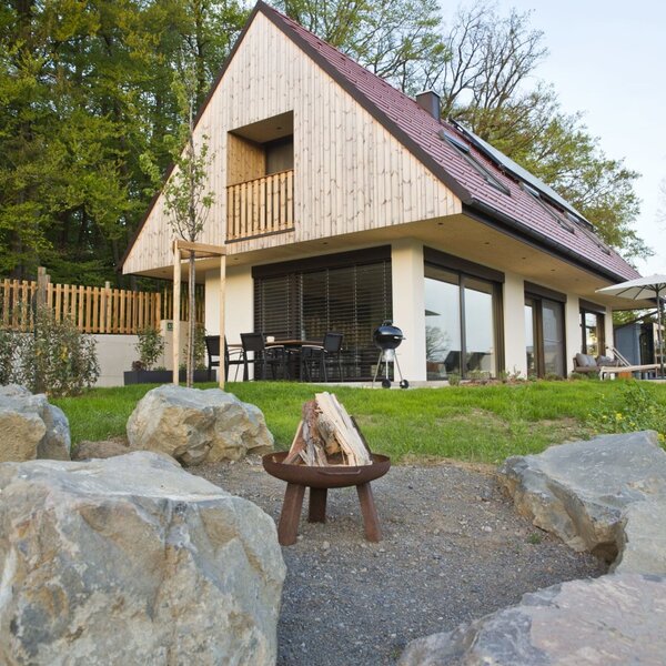 Außenansicht des Bauernhofs mit Balkon im Obergeschoss, Terrasse, Essbereich, Grill, Whirlpool und einer Feuerschale.